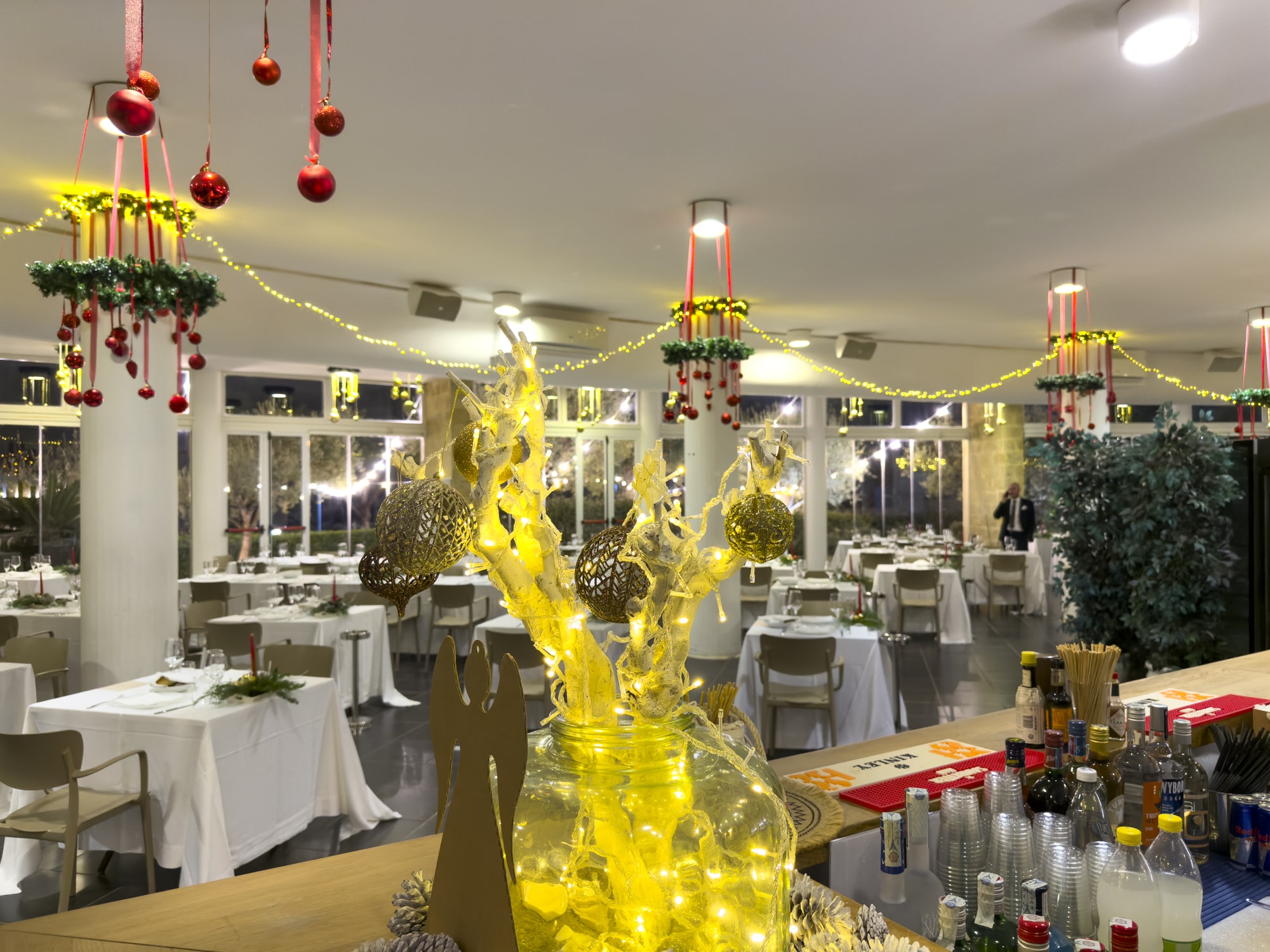 Tavoli imbanditi e decorazioni natalizie nella sala del Cala Corvino Resort per il Cenone di Capodanno 2025 a Monopoli.