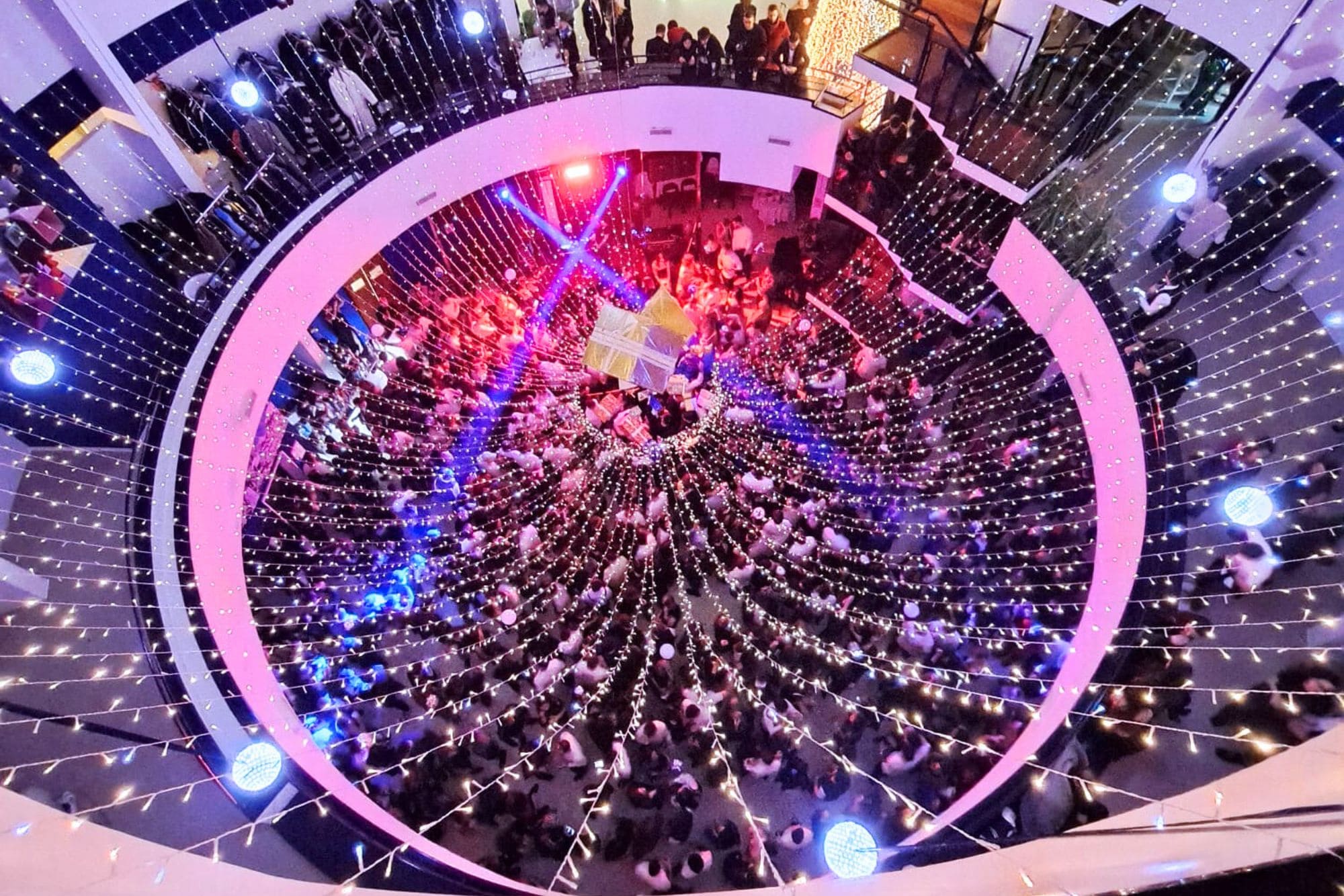 Festa di Capodanno al Cala Corvino Resort di Monopoli vista dall’alto, con luci e musica nella sala centrale dopo la mezzanotte.