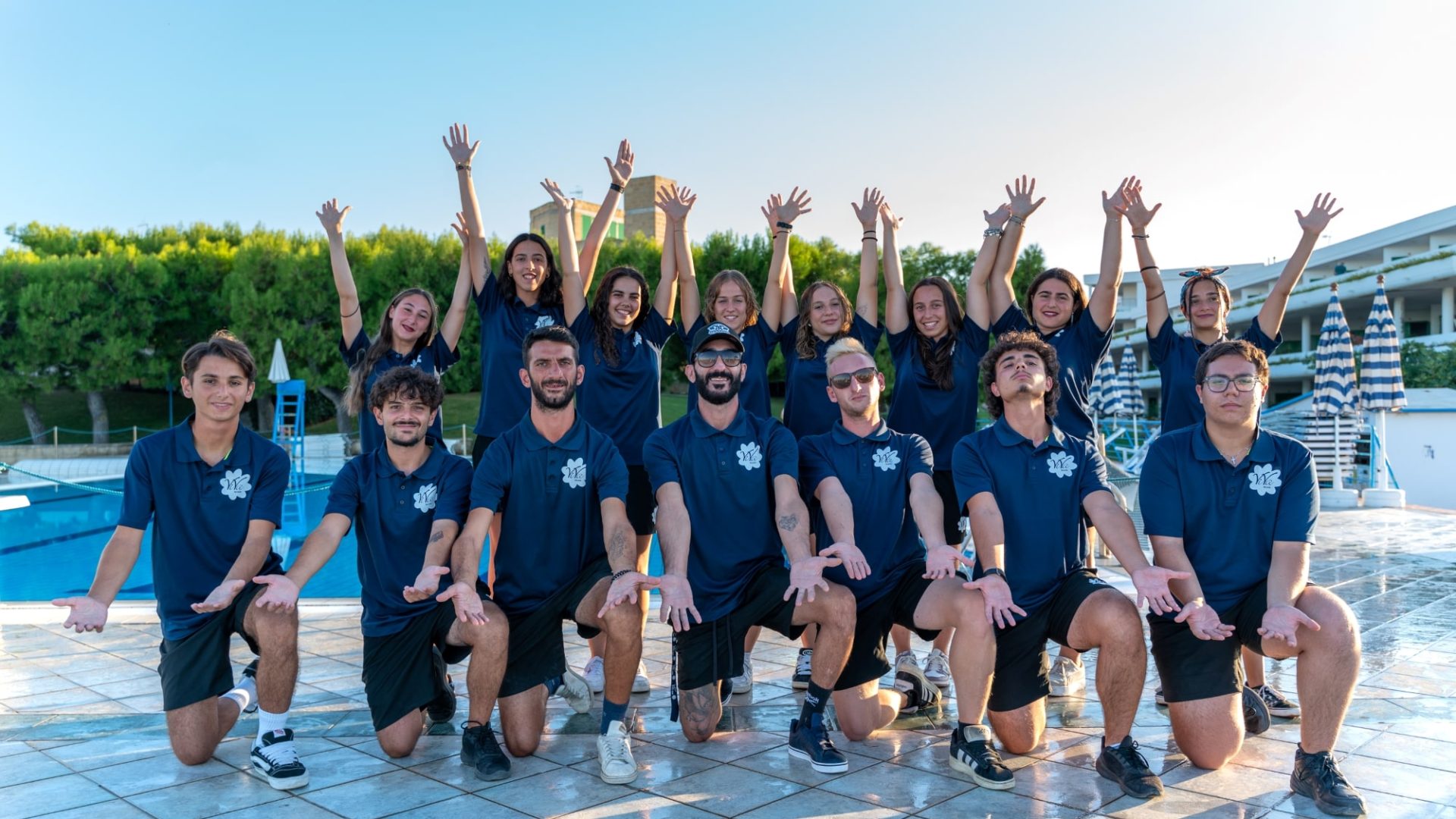 Gruppo dello staff di animazione del Cala Corvino Resort per l’estate 2025, in posa gioiosa accanto alla piscina.